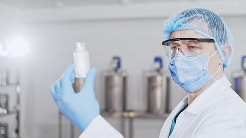 Medical Professional Examining a Bottle of Medicine in Lab