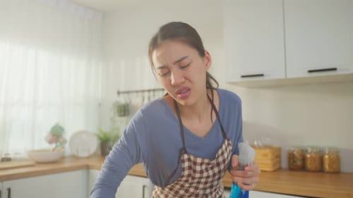 Asiatische schöne Putzfrau, die zu Hause die Küche putzt.