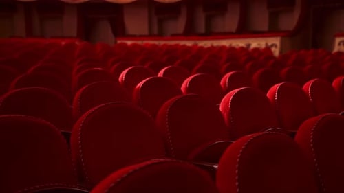 Red chairs background. Rows of comfortable chairs without people in a theatrical hall. Empty auditor