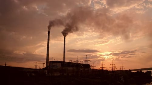 Harmful industrial area near the river. Power plant with smoking pipes pollute the atmosphere.
