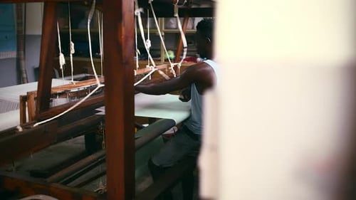 Man, floor treadle loom and weaving for production at clothing factory, manufacture