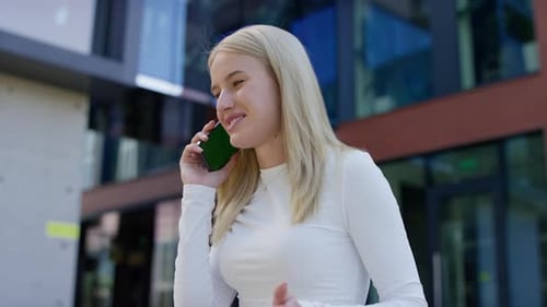 Smiling Woman Speaking on Phone Call Outdoors