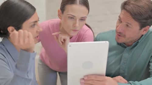 Close up of Multi Ethnic People Discussing Work on Tablet