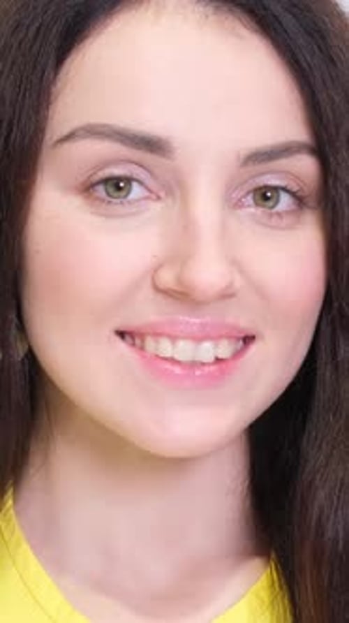 Portrait of a Beautiful Brunette on a White Background in the Studio Vertical Video