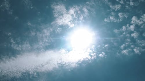 Sun in Clear Blue Sky and Slightly Cloudy, Time Lapse, Slow Motion. Sunny Summer Sky Glowing Sun