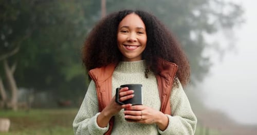 Smiling Woman Holding Mug in Foggy Nature Setting