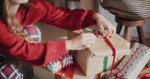 Woman Unties Ribbon on Christmas Presents