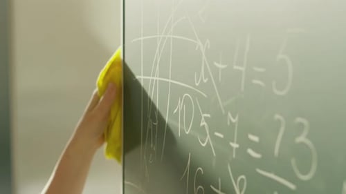 A Girl Student Writes on a Green Board