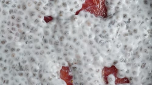 Top View as a Spoon Scoops Chocolate Pudding with Chia Seeds and Strawberries. Close-up.