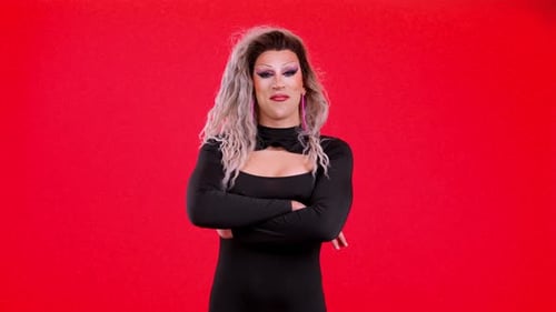 Glamorous Drag Queen Poses on Red Backdrop