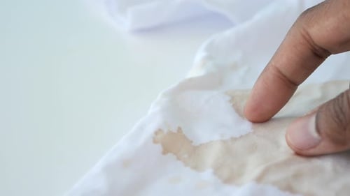 Finger Poking at a Stain on White Cloth