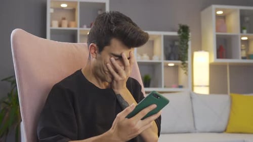 Sad and offended man not looking at phone.