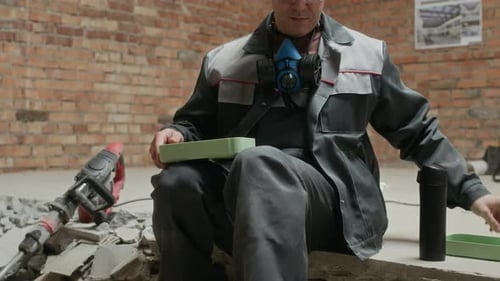 Construction Worker Eating Lunch in Building Interior