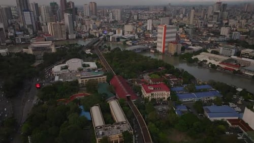 High Angle View of Parks and Gardens Along River Tilt Up Reveal Modern Metropolis with High Rise