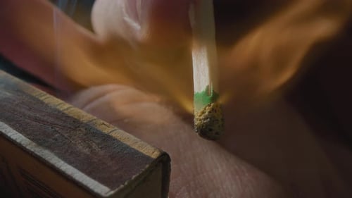 Hands Lights a Match with a Green Sulfur Head Slow Motion Strikes a Match on the Side of the Box