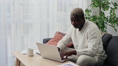 Man Working on Laptop in Bright Home Office