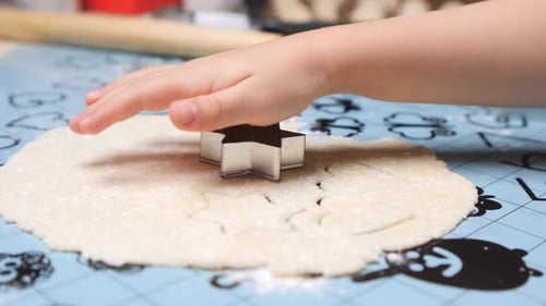 Child Cuts Star Shapes From Cookie Dough