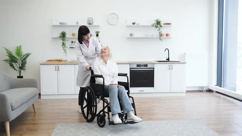Woman in Wheelchair Smiling, Nurse in Bright Modern Kitchen