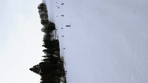 Imágenes verticales: esquiadores esquiando cuesta abajo en las montañas del centro vacacional de invierno