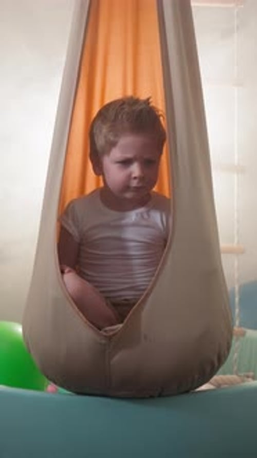 Cute Blond Toddler Frowns Moving Head to Sides in Home Gym