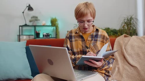 Young Adult Working on Laptop and Writing