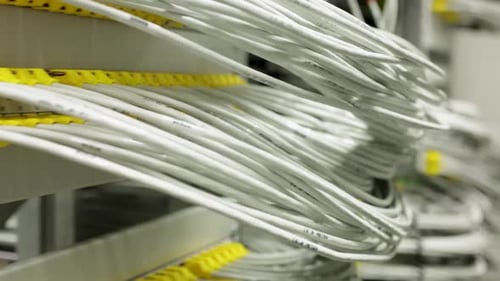 Innumerables cables blancos, verdes y amarillos en una sala de servidores o un centro de datos