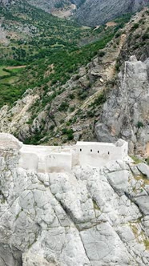 Vue aérienne par drone d'une forteresse historique construite le long de falaises spectaculaires surplombant un canyon v