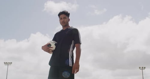 Young Adult Holding a Soccer Ball on Field