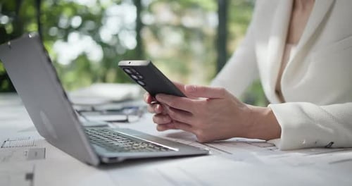 Professional Woman Using Smartphone in Design Workplace