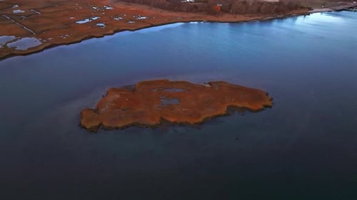 An aerial view over a patch of marsh grass in a salt marsh by Freeport, New York during a cloudy day