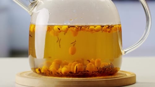 Argousier, baies saines pour le thé, boisson, baies mûres surgelées dans un bocal en verre et branches avec