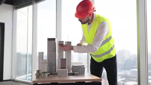 Bearded Engineer in Protective Helmet Working on Building Complex Prototype Project