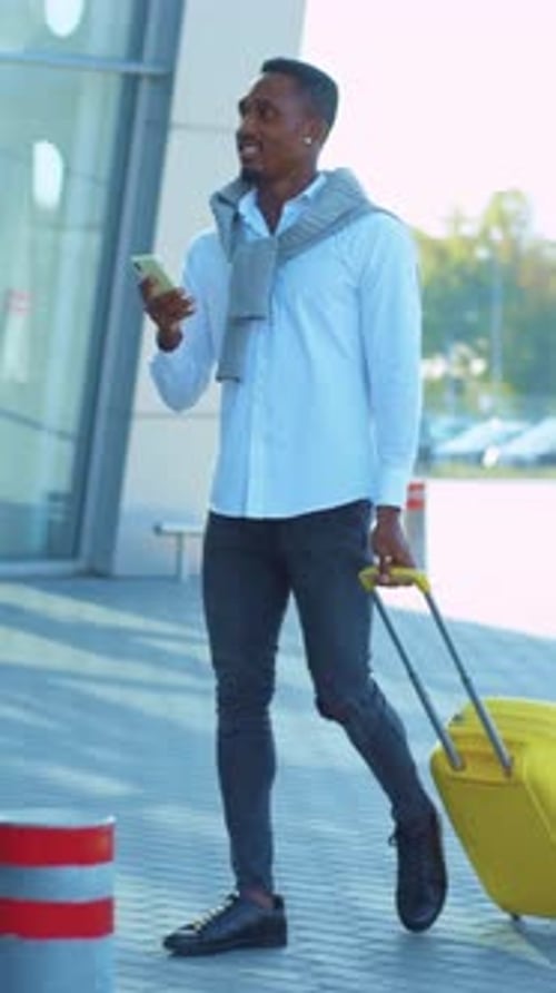 Stylish Man with Suitcase Using Phone in City