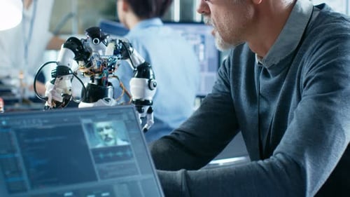 Robotics Engineer Manipulates Voice Controlled Robot, Laptop Screen Shows Speech and Face Reconizin