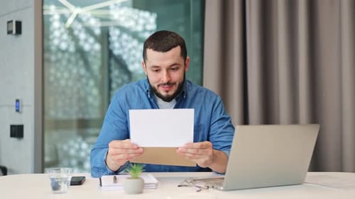 Excited Man Reads Good News in Office Letter
