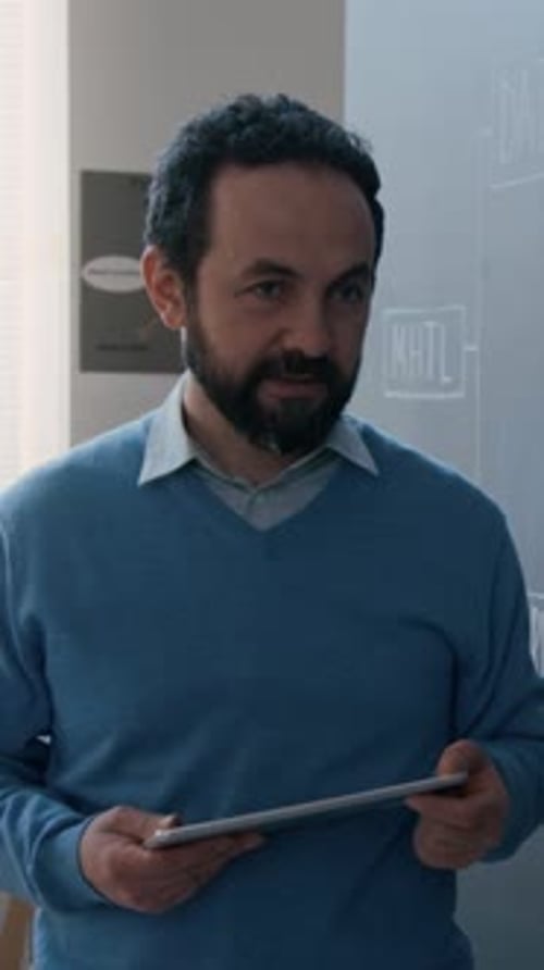 Vertical of Coding Teacher with Tablet Explaining Algorithm to Class