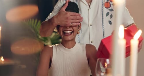 Happy, couple and surprise gift at restaurant for romance, valentines day date and celebration