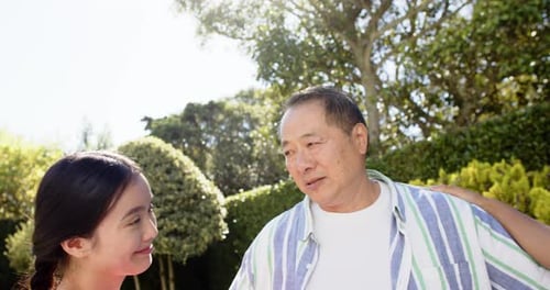 Happy Family Hugging Outdoors in Sunny Garden