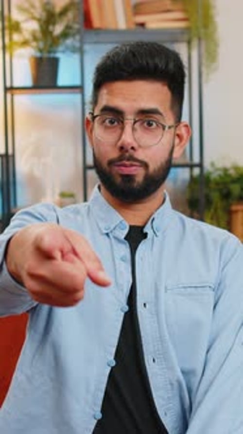 Glücklicher zufriedener Inder, der lächelt und in die Kamera zeigt, wählt den glücklichen Gewinner aus und wählt „Genehmigen“