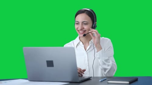 Happy Indian call center girl talking to customer through call Green screen