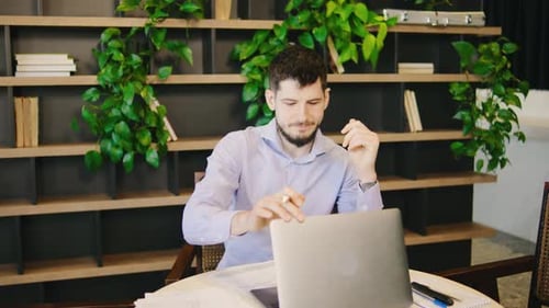 Man Working on Laptop in Office Deep in Thought