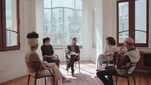 Adults in a Group Conversation in Bright Room