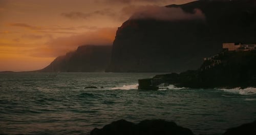 Rocky Beach Landscape with Dark Ocean Water Waves at Summer Golden Hour Los Gigantes Cliffs and
