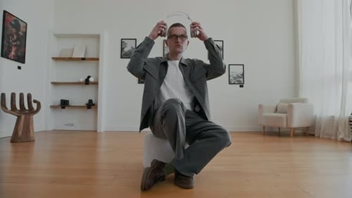 Mann setzt große Kopfhörer in der Kunstgalerie auf