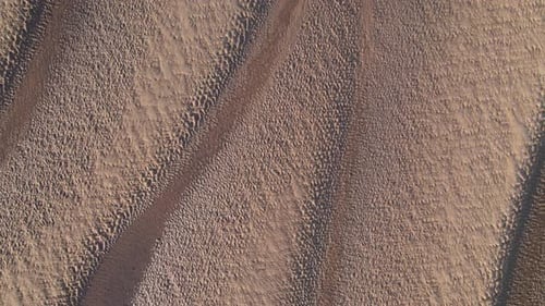 Sand texture. Sandy beach for background. Aerial birdseye flying forward