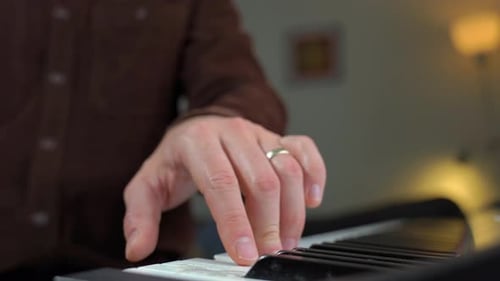 Close Up of Hand Playing Piano Keyboard