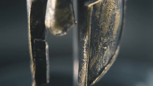 A close up spiral slow tilt up shot of a spartan face design, warrior ancient greek bronze helmet, o