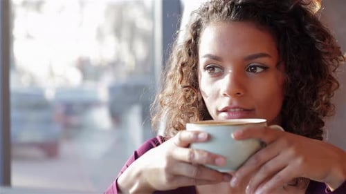 Young Woman Enjoys Coffee Close Up