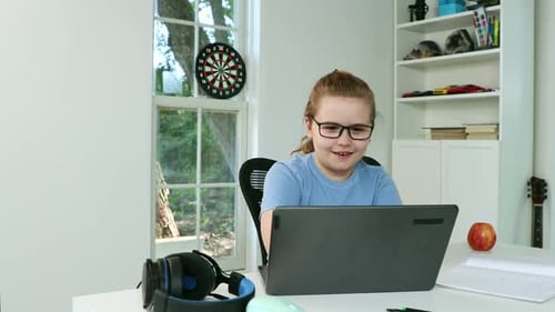 Girl Studies Using Laptop Computer at Home Desk
