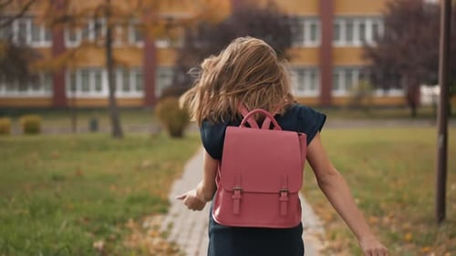 Fröhliches Schulmädchen rennt zur Schule